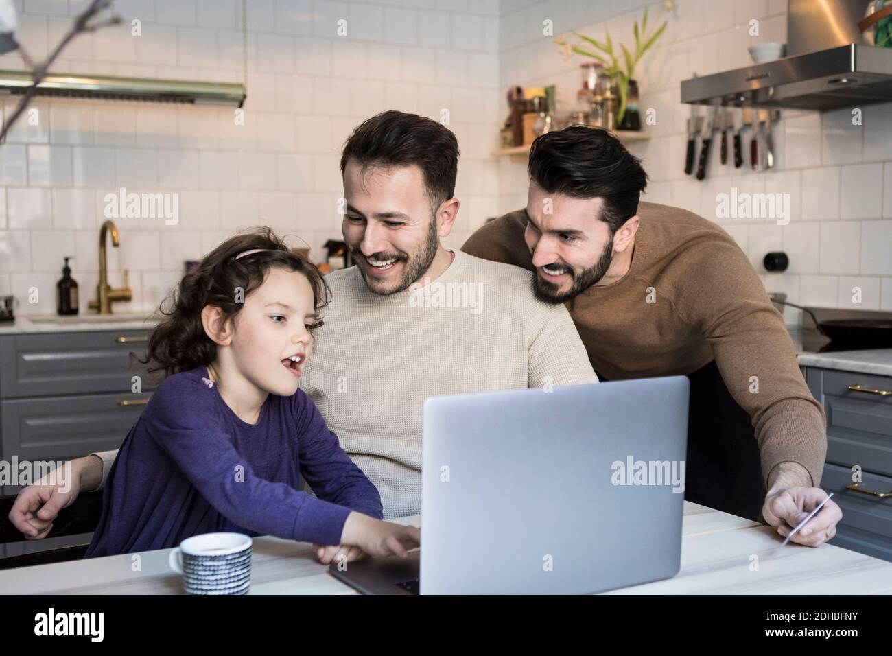 Happy gay couple using laptop hi-res stock photography and images - Alamy