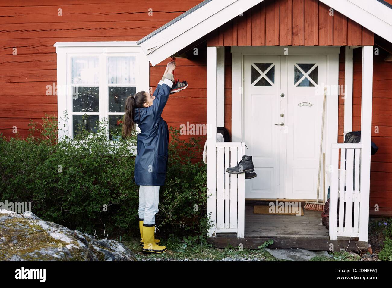 Side view of young woman drying shoes outside house Stock Photo Alamy