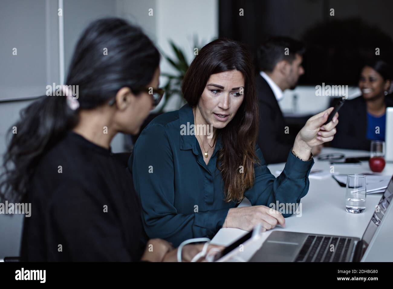 Business people discussing while working at conference table in board ...