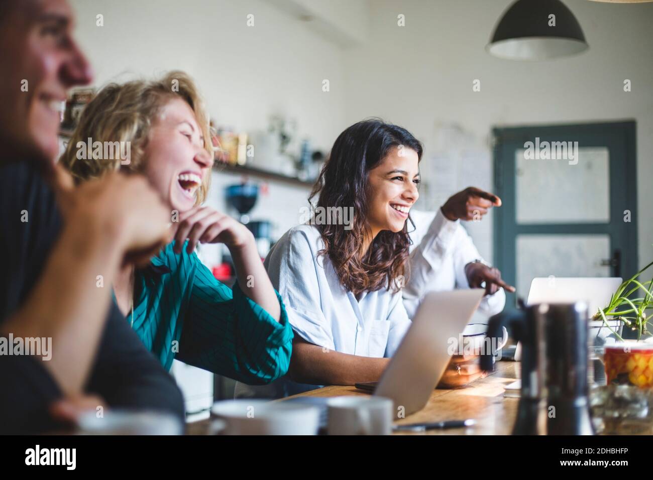 Confident cheerful IT professionals sitting at table while working in creative office Stock Photo