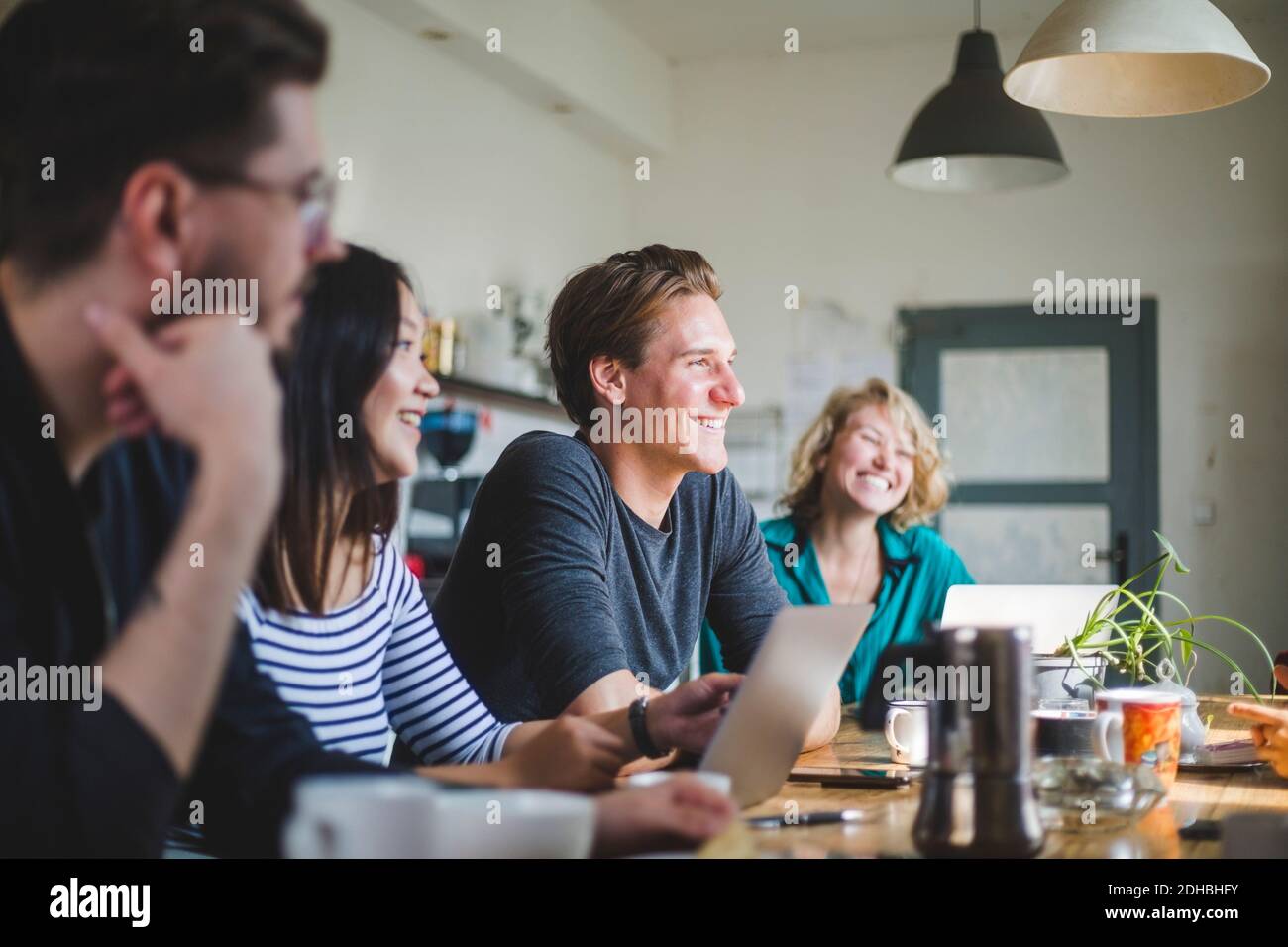 Happy computer programmers looking away while working at table in office Stock Photo