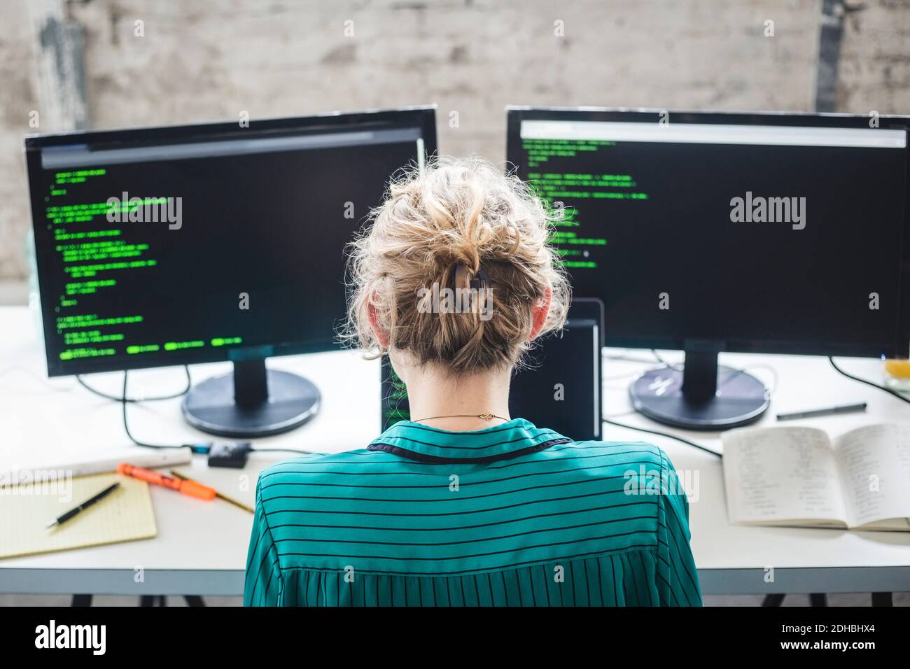 High angle view of female IT expert working on computer programs at desk in creative office Stock Photo