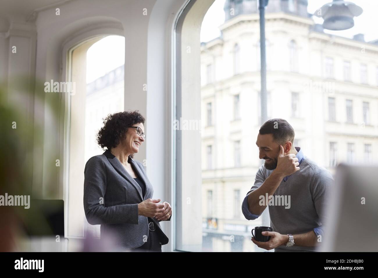 Smiling business colleagues communicating at office Stock Photo