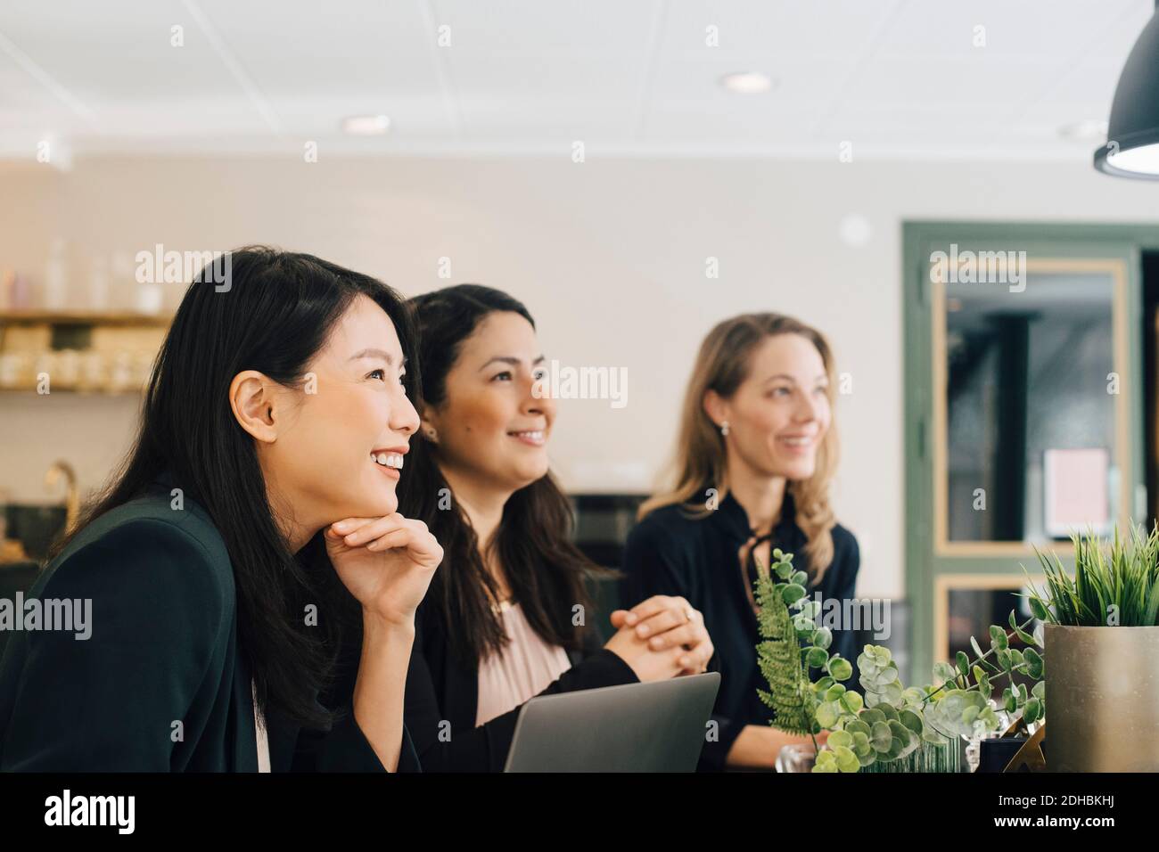 Smiling businesswomen sitting at conference table in meeting Stock Photo