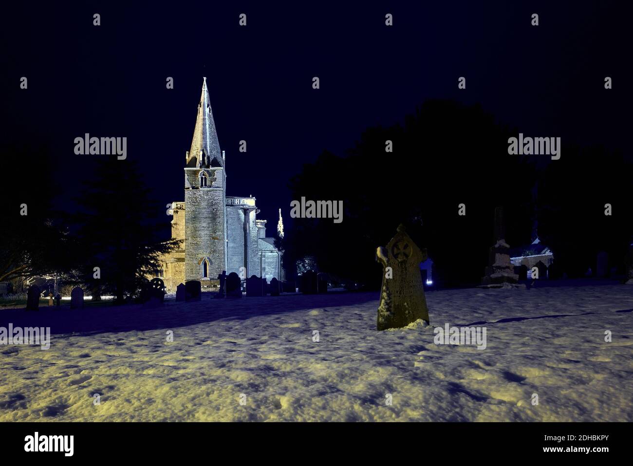 St Bartholomew's church and churchyard, Welby Lincolnshire in the snow at night during winter December Stock Photo