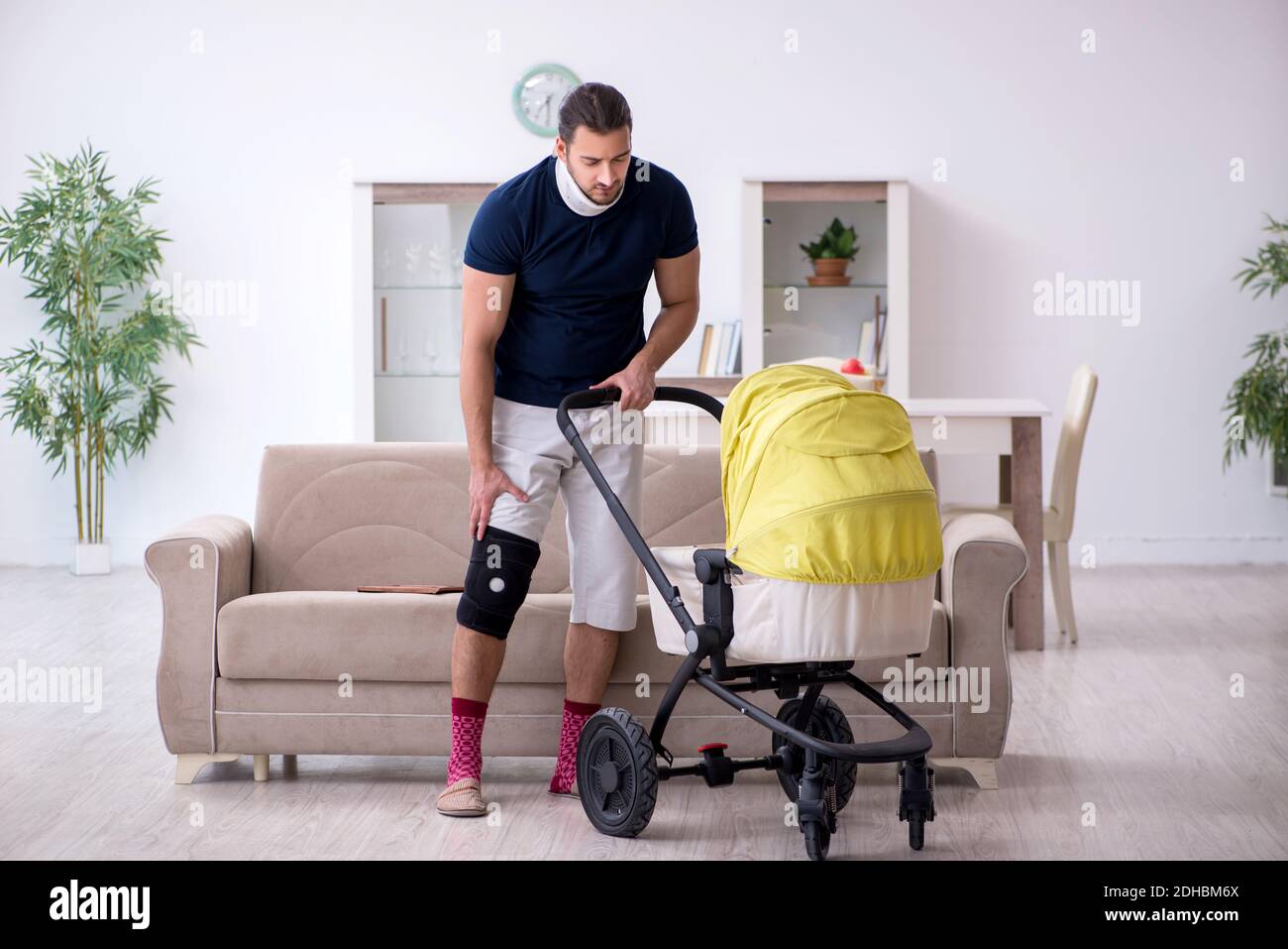 Young man after accident looking after newborn Stock Photo