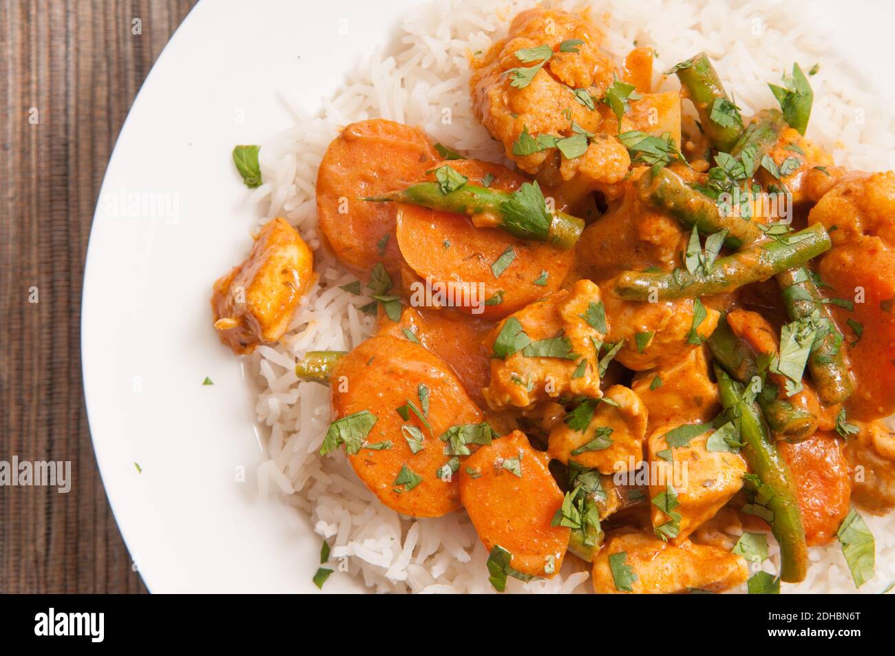chicken korma with a spicy sauce over white rice Stock Photo Alamy