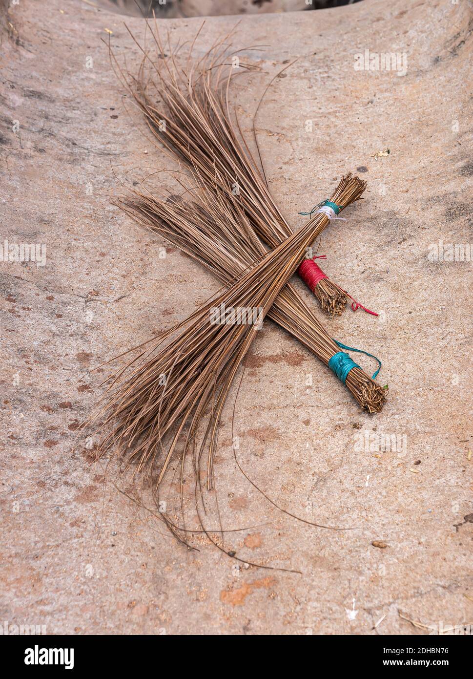 Hampi, Karnataka, India - November 4, 2013: Tungabhadra River just north of Viriupaksha Temple complex. Closeup of 3 hand brooms made from palm tree l Stock Photo