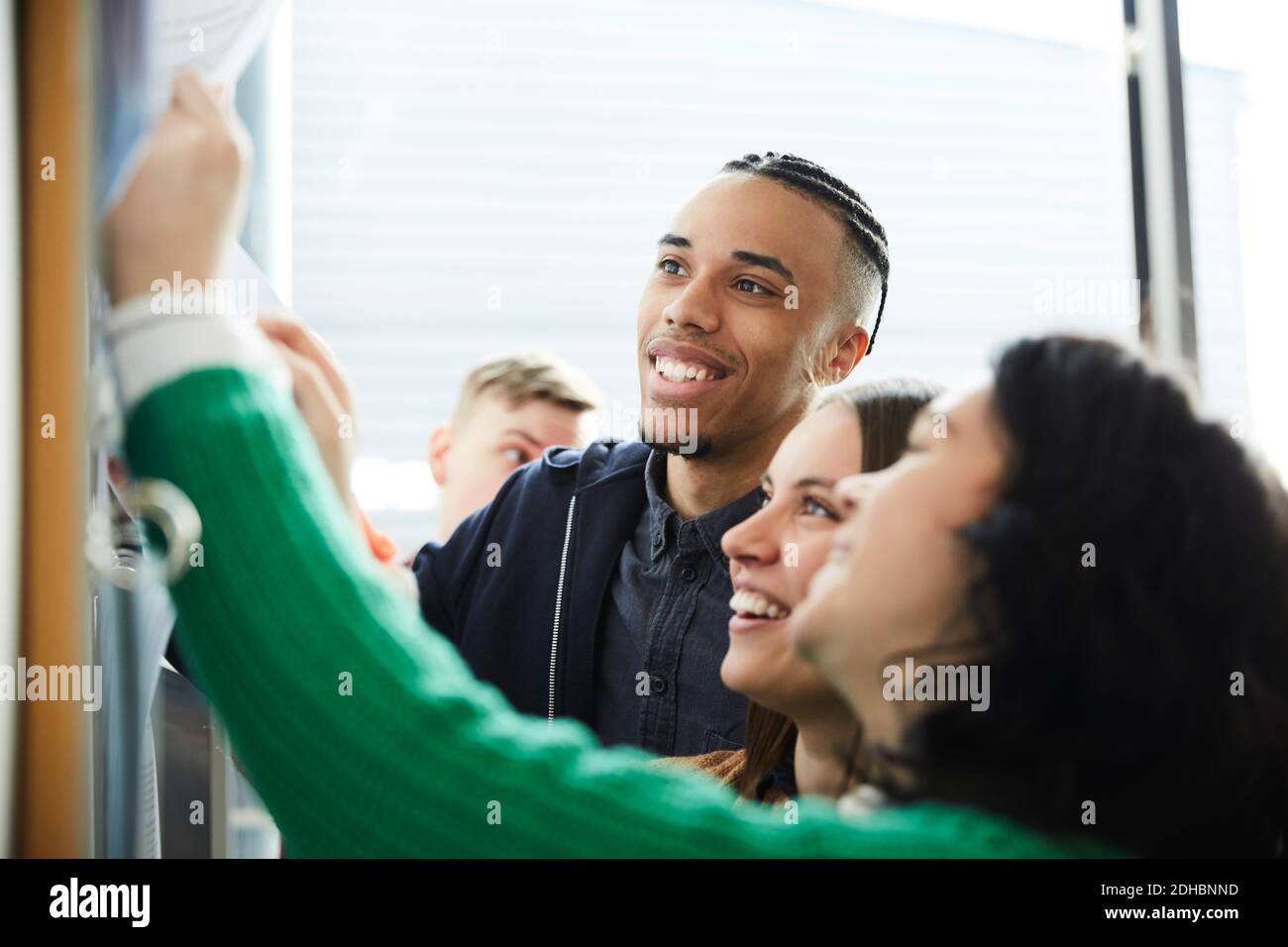 Happy university students checking bulletin board for test results Stock Photo