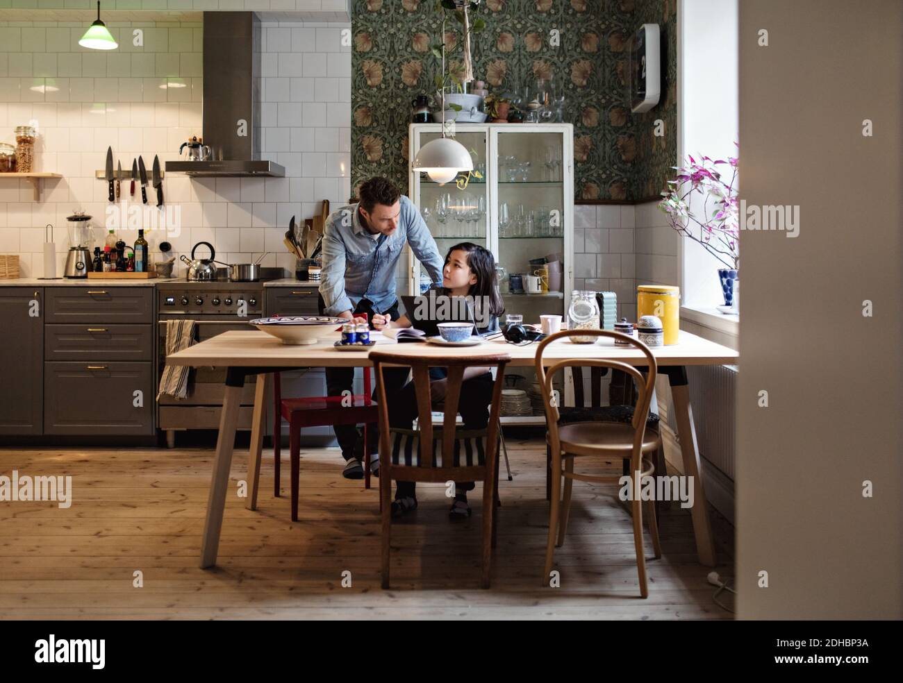 Father helping son in doing homework at home Stock Photo