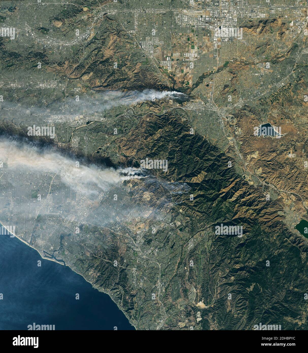 Smoke plumes rise from the Airport and Silverado Canyon wildfires show by the Operational Land Imager on the Landsat 8 satellite December 3, 2020 near Los Angeles, California. Stock Photo