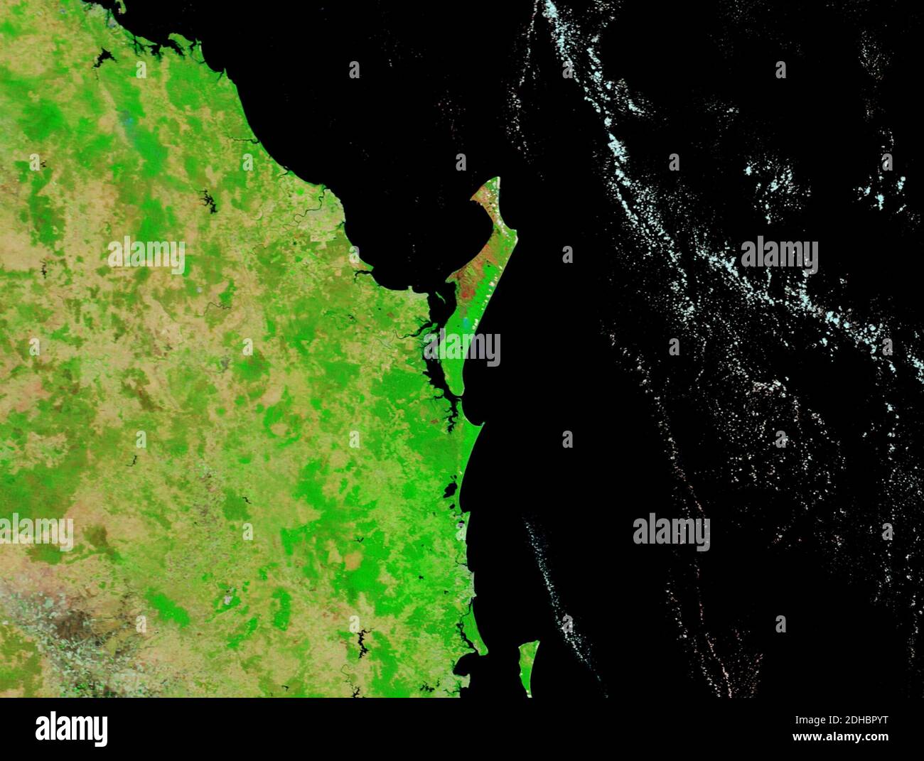 Burn scares in brown contrast against the green vegetation caused by bush fires on the eastern side of Fraser Island as observed by MODIS on board the NASA Terra satellite December 5, 2020 on Fraser Island, Australia. An illegal campfire ignited brush and swept through the unique forests destroying half of the World Heritage Site and threatening local wildlife. Stock Photo