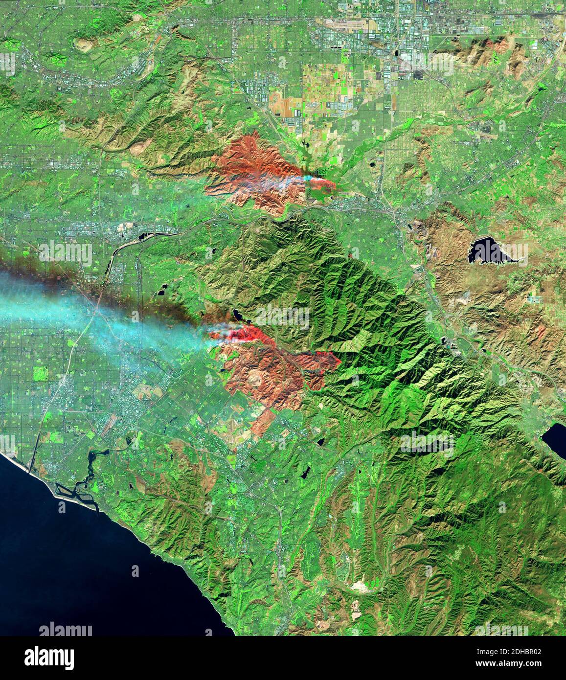 Smoke plumes rise from the Airport and Silverado Canyon wildfires show by the Operational Land Imager on the Landsat 8 satellite December 3, 2020 near Los Angeles, California. Stock Photo