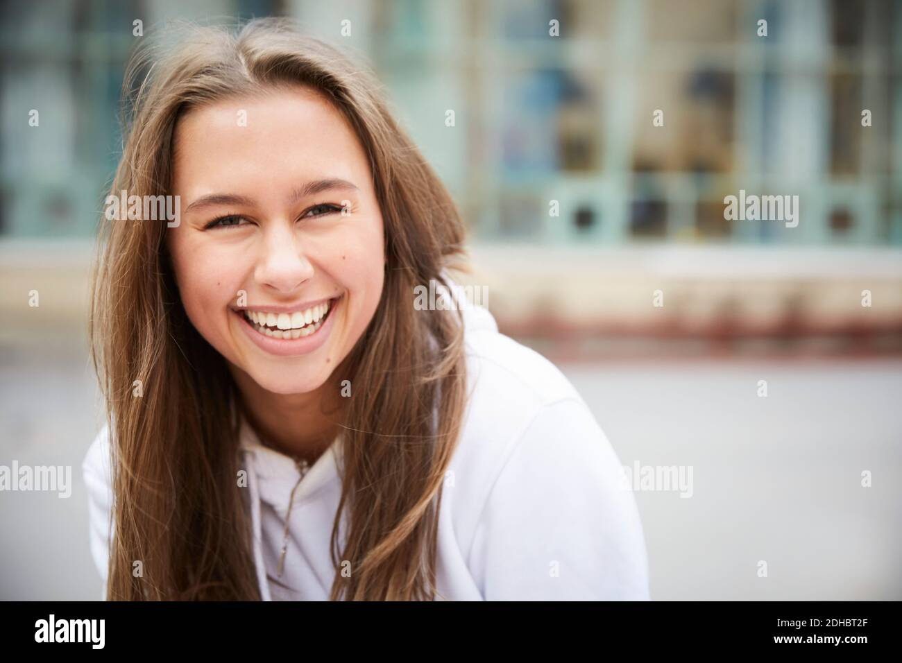 Portrait of smiling teenage girl sitting in schoolyard Stock Photo - Alamy