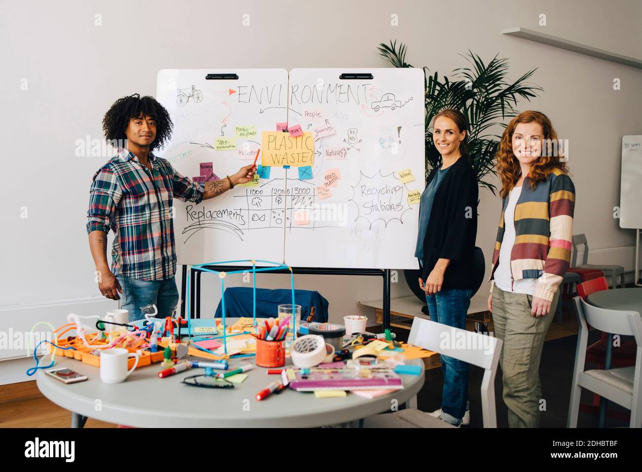 Portrait of confident technician team standing strategy on whiteboard at creative office Stock Photo