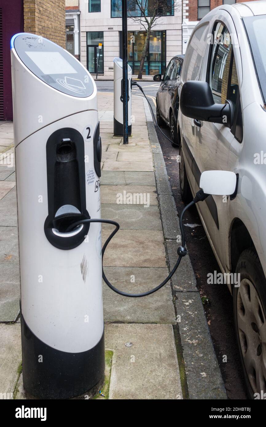 Electric vehicles plugged in and charging on roadside parking Stock ...