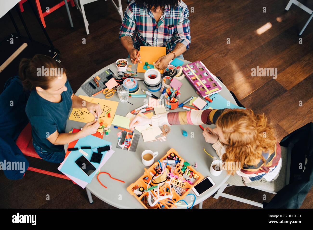 High angle view of multi-ethnic engineers working at table in creative office Stock Photo