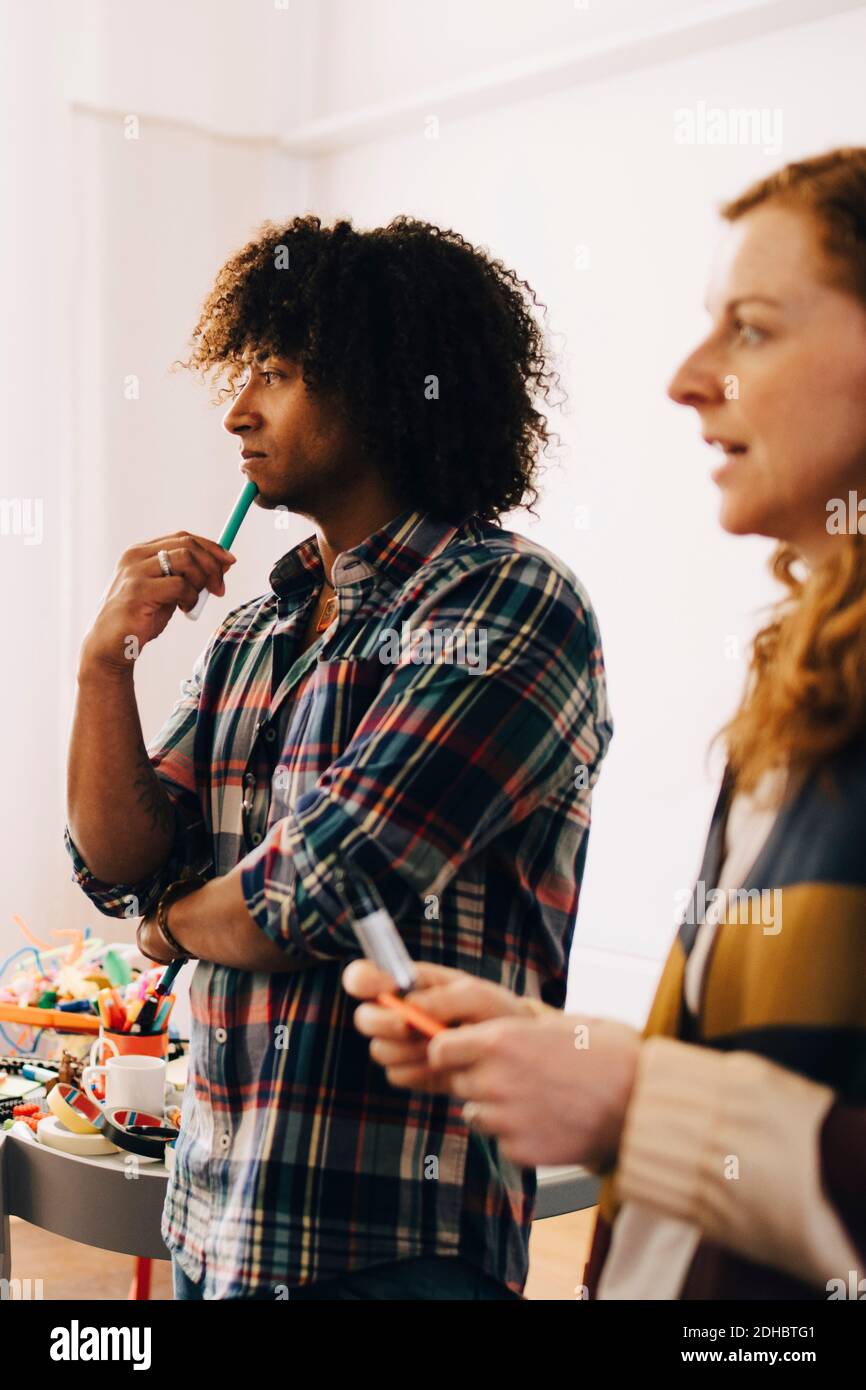Multi-ethnic technicians looking away while standing at creative office Stock Photo