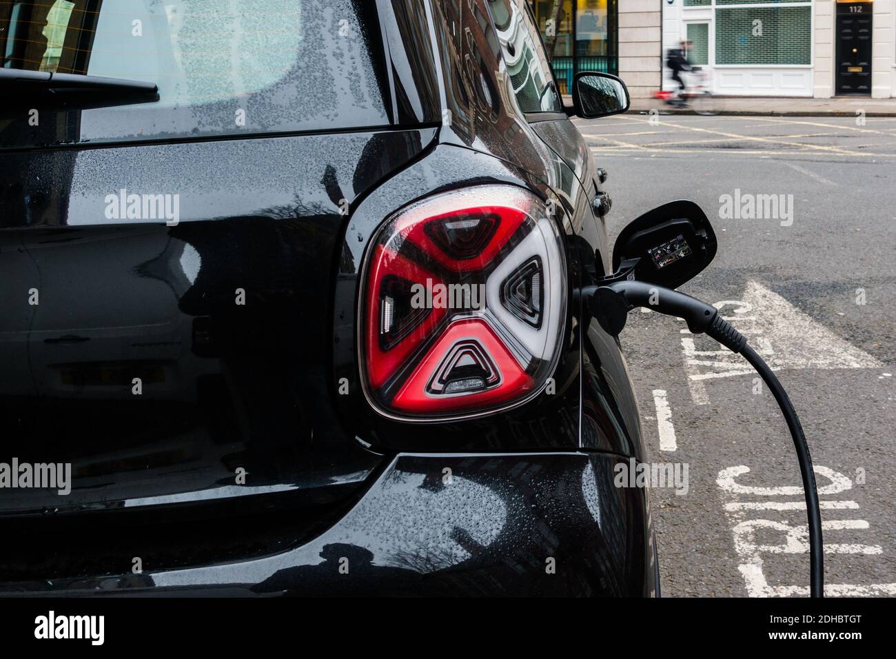 Electric car plugged in for charging close up view Stock Photo Alamy