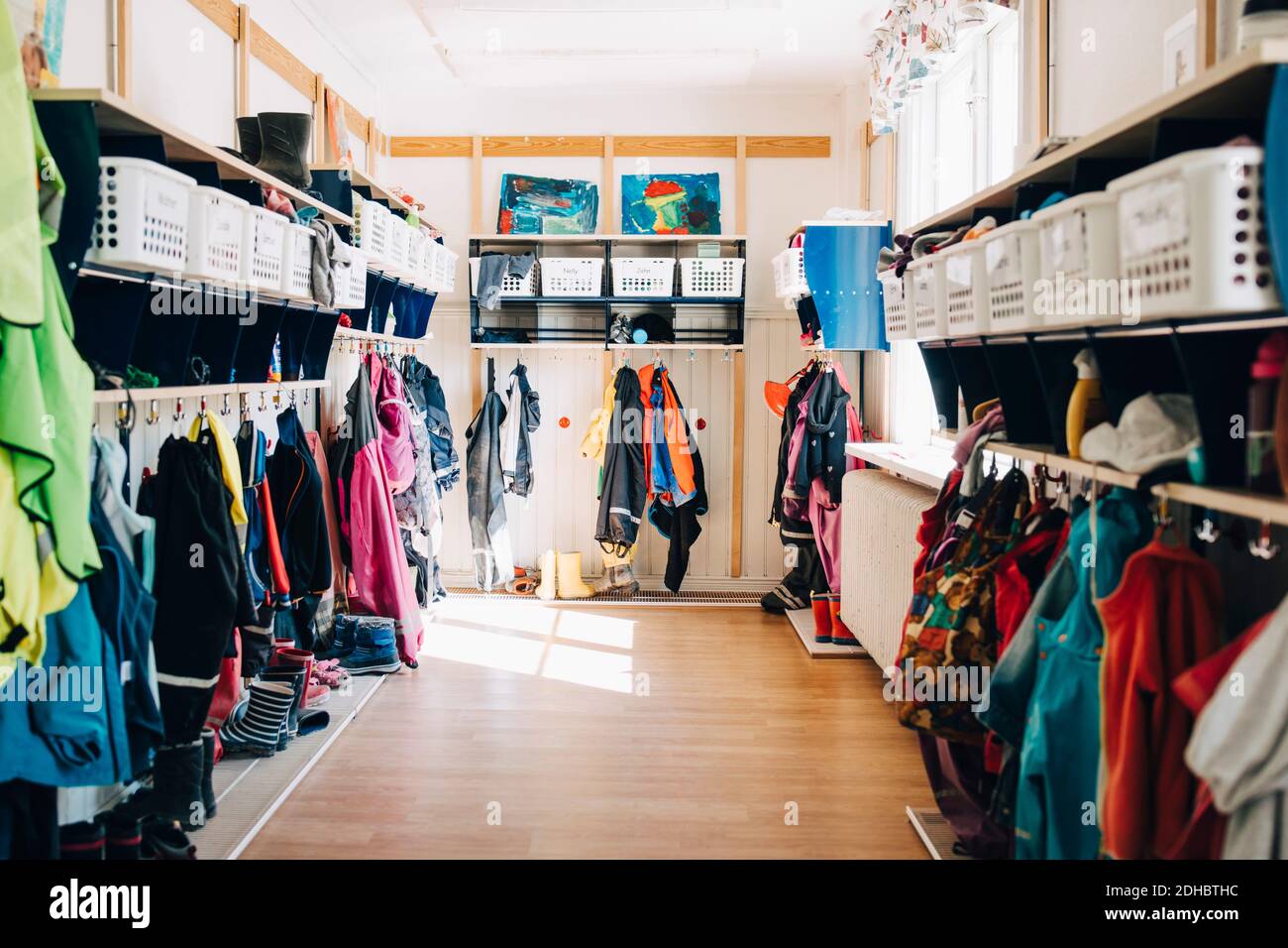 Various clothes hanging in cloakroom at preschool Stock Photo