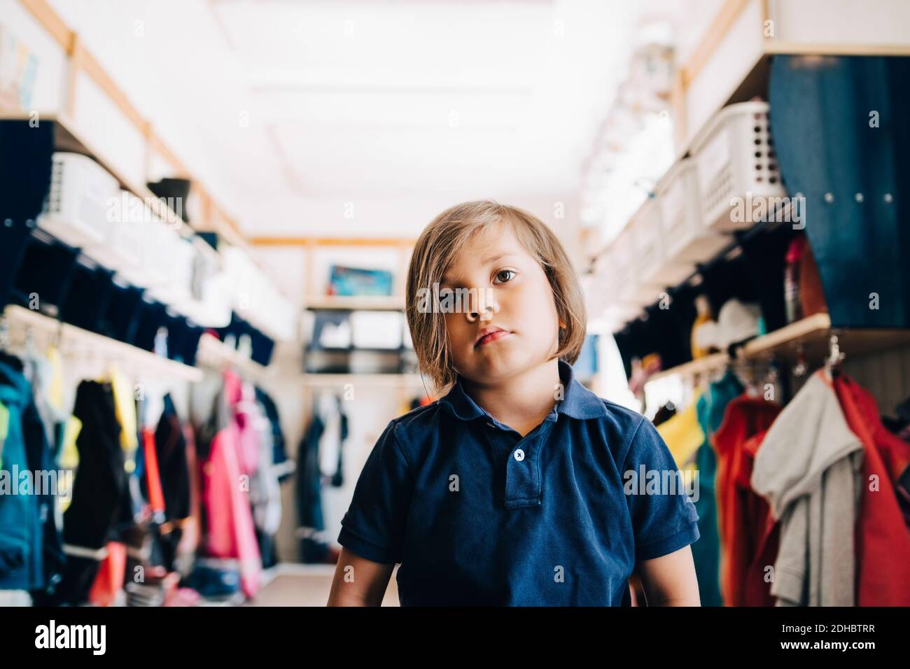 Boy sitting in cloakroom at kindergarten Stock Photo