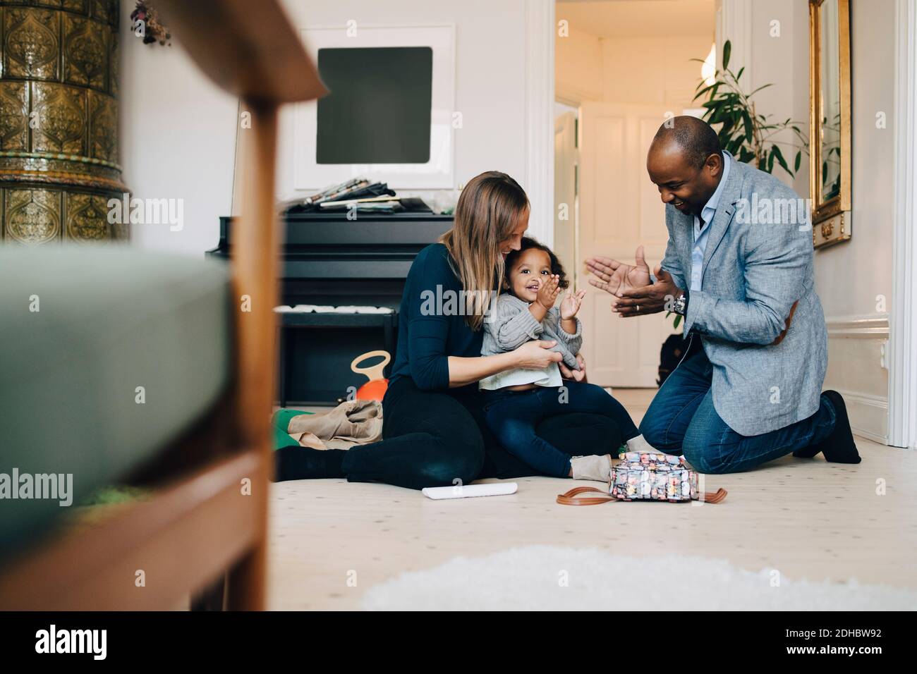 Parents playing with daughter while sitting in living room at home Stock Photo