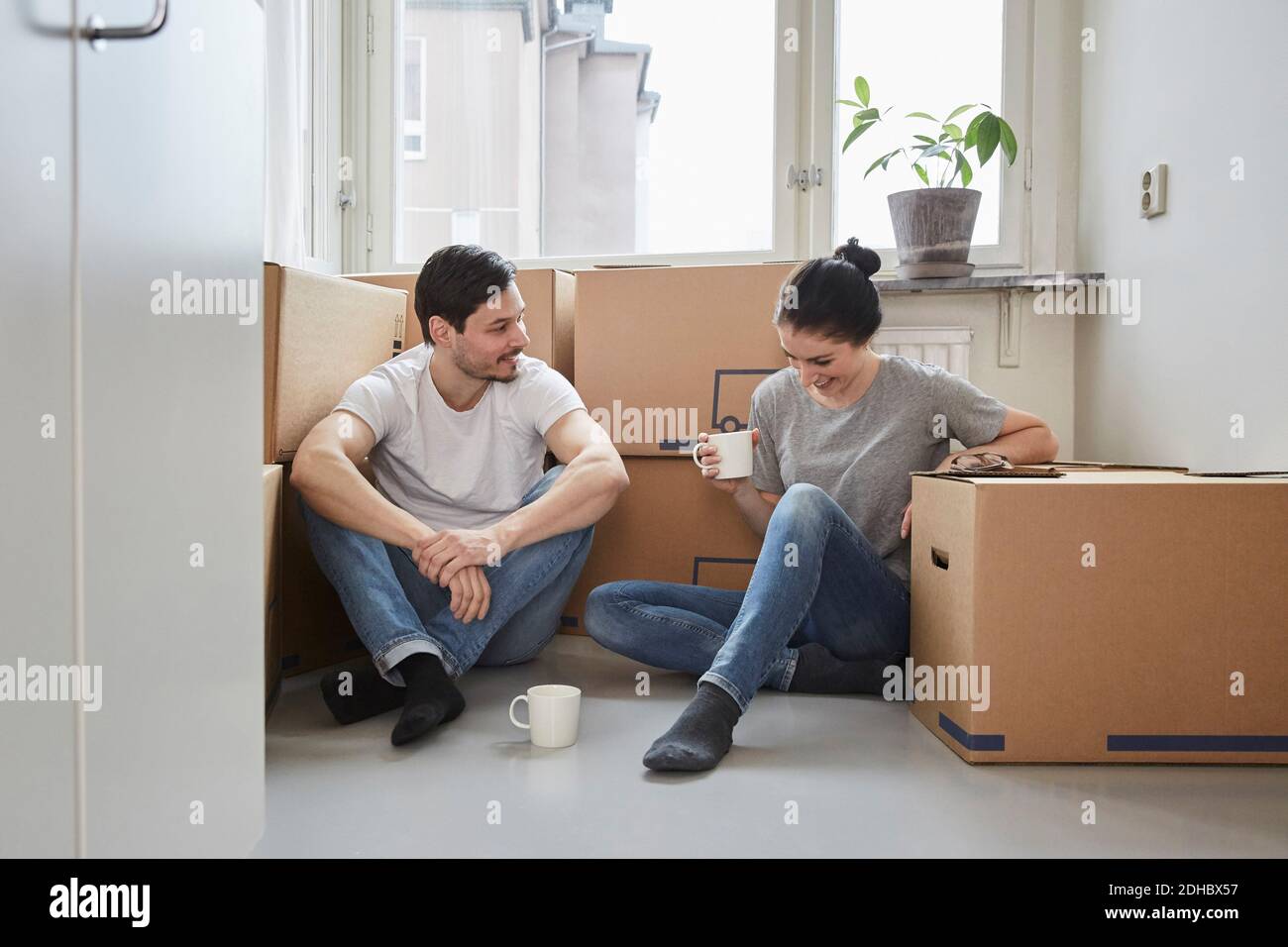 Smiling couple talking while enjoying coffee during moving house Stock Photo
