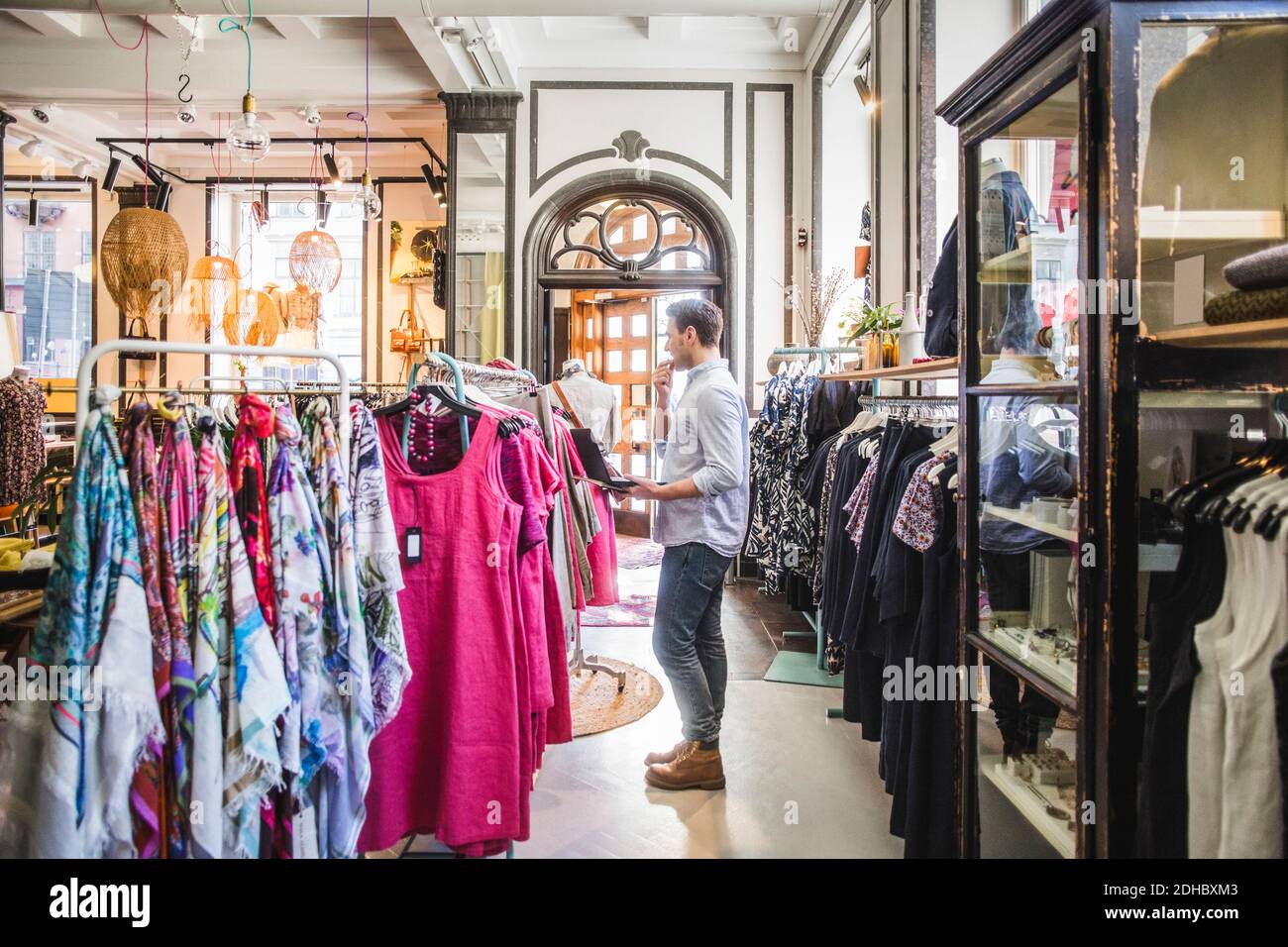 Side view of store owner verifying stock in boutique Stock Photo