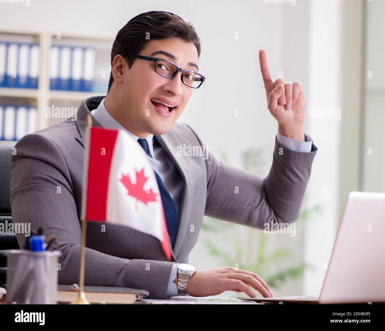 Businessman with Canadian flag in office Stock Photo - Alamy