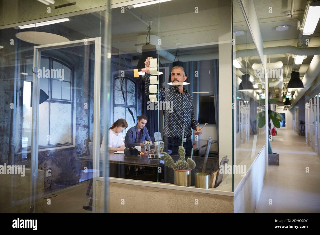 Creative business people working in board room seen through glass Stock Photo