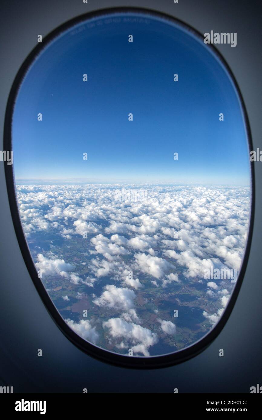 View of clouds through airplane window Stock Photo