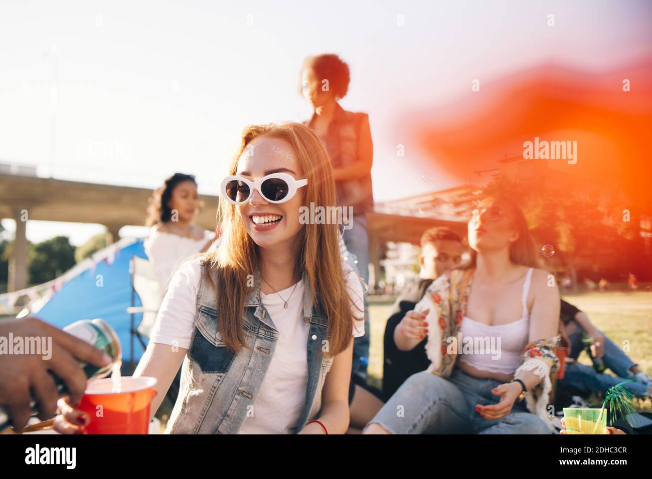 Cropped image of man pouring alcohol to smiling woman at festival Stock Photo