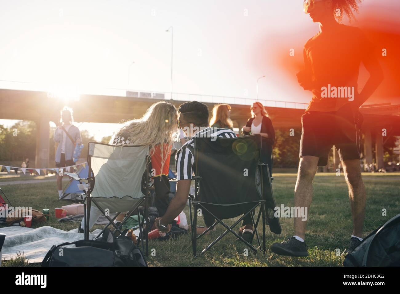 Rear view of loving couple sitting on folding chairs in music concert duiring summer Stock Photo