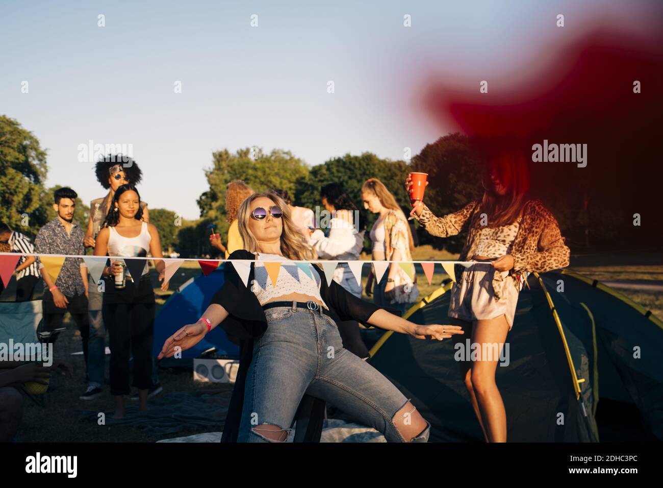 Young friends performing limbo dance while camping in music festival Stock Photo Alamy