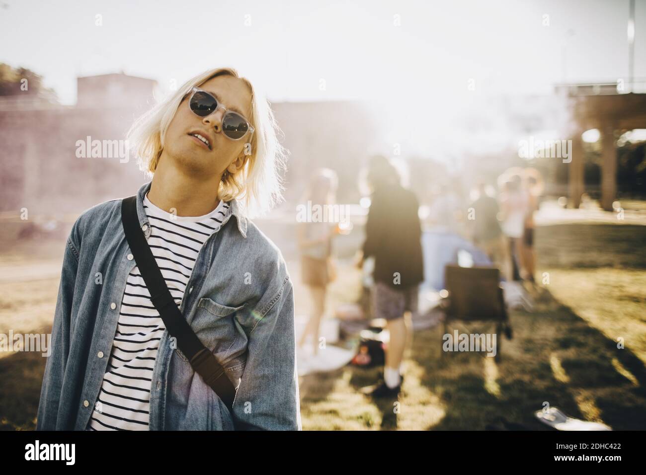 Portrait of young confident man wearing sunglasses standing in music festival Stock Photo