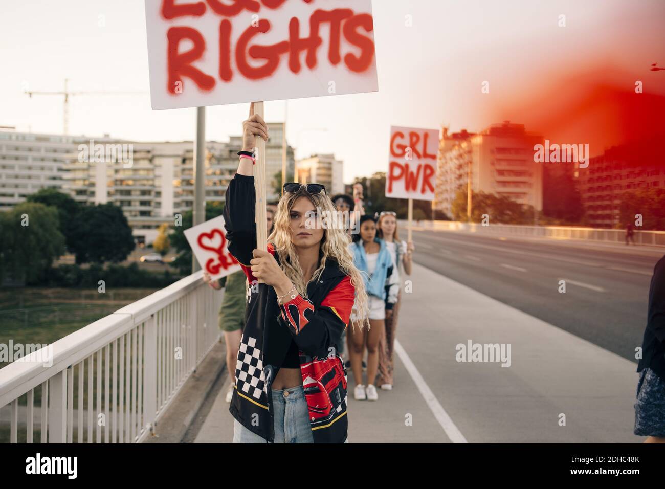 Women with posters marching for equal rights against sky in city Stock Photo