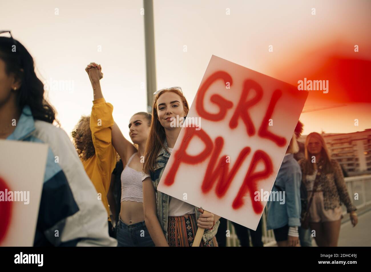 Portrait of women protesting with friends for human rights in city against sky Stock Photo