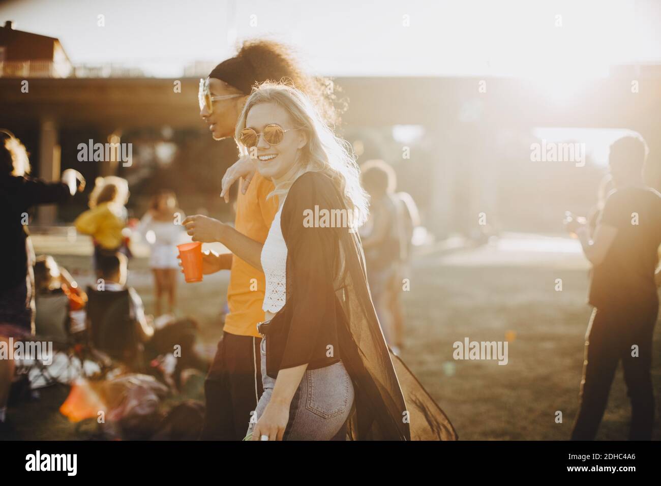 Smiling woman walking with friend at concert Stock Photo