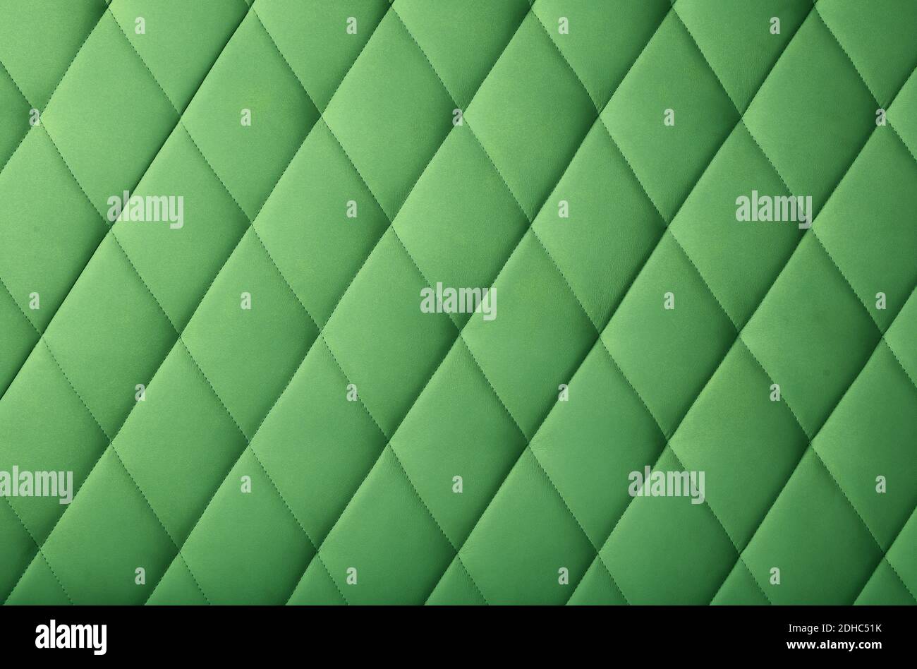 Background texture of pastel dark green genuine leather soft tufted furniture or wall panel upholstery with deep diamond pattern, close up Stock Photo