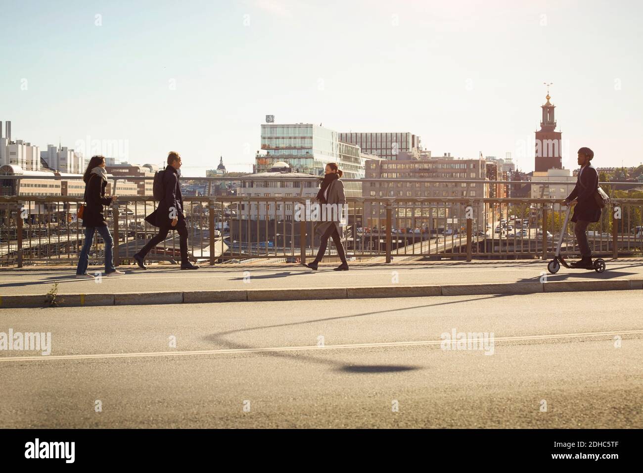 Full length of commuters on bridge in city Stock Photo