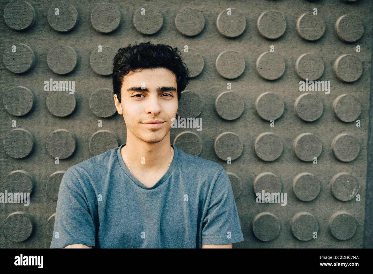 Portrait of confident young man standing against wall Stock Photo - Alamy