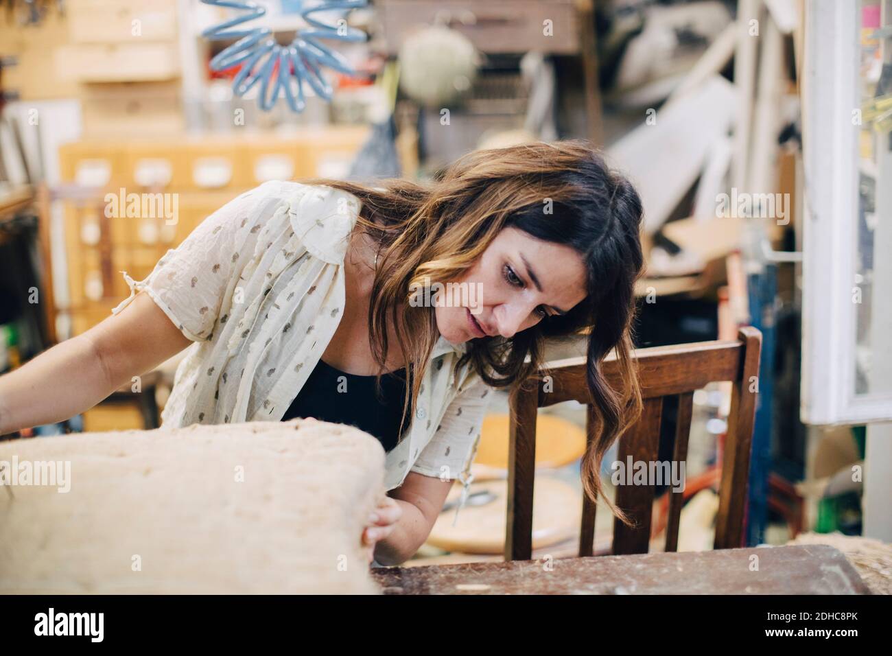 Mid adult female craftsperson making furniture in workshop Stock Photo