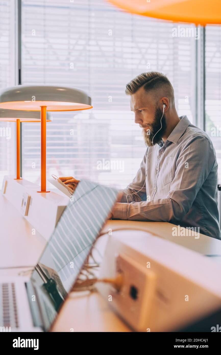 Confident businessman using digital tablet while waiting at airport Stock Photo