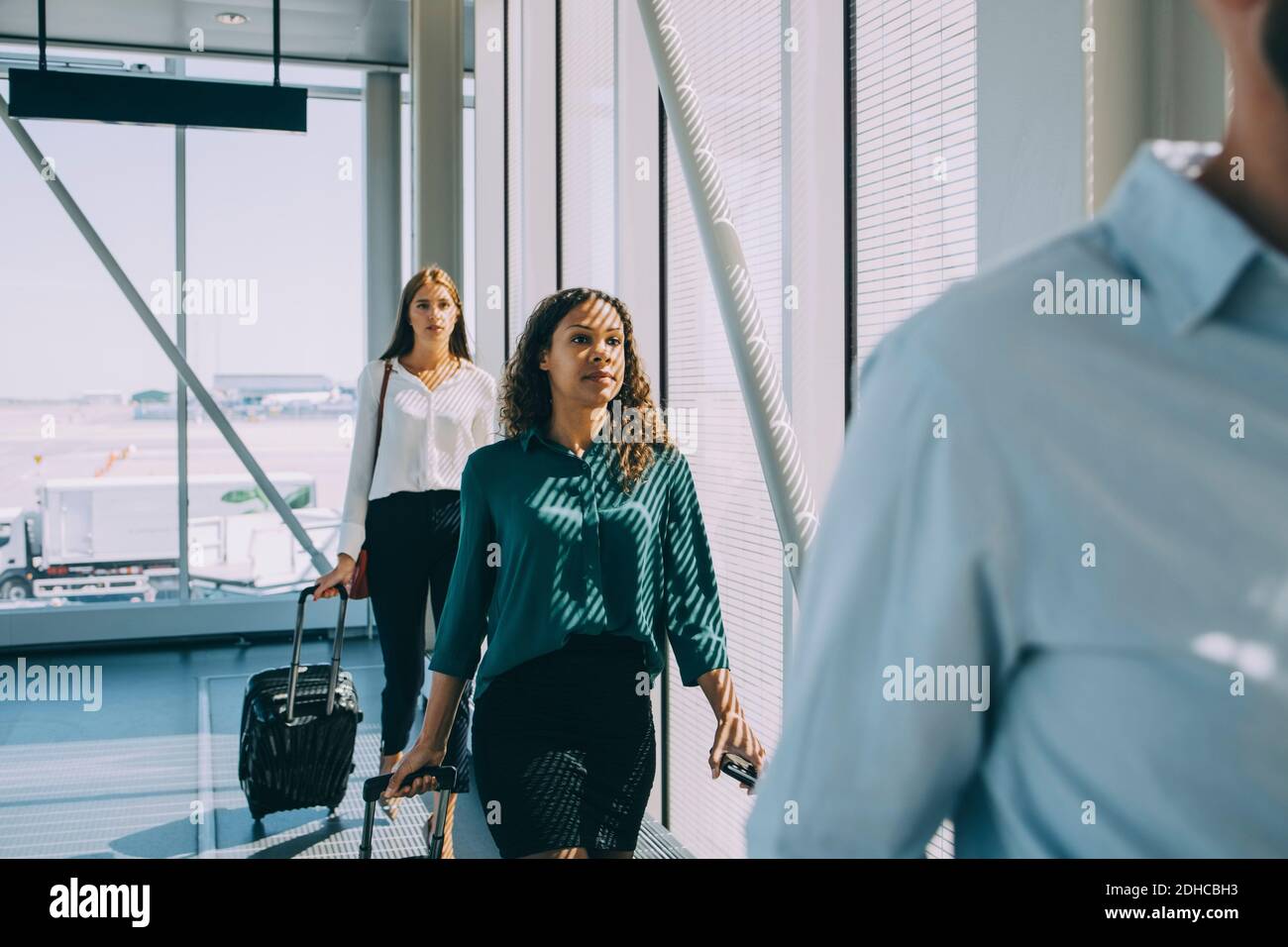Row of multi-ethnic business colleagues walking in corridor at airport Stock Photo