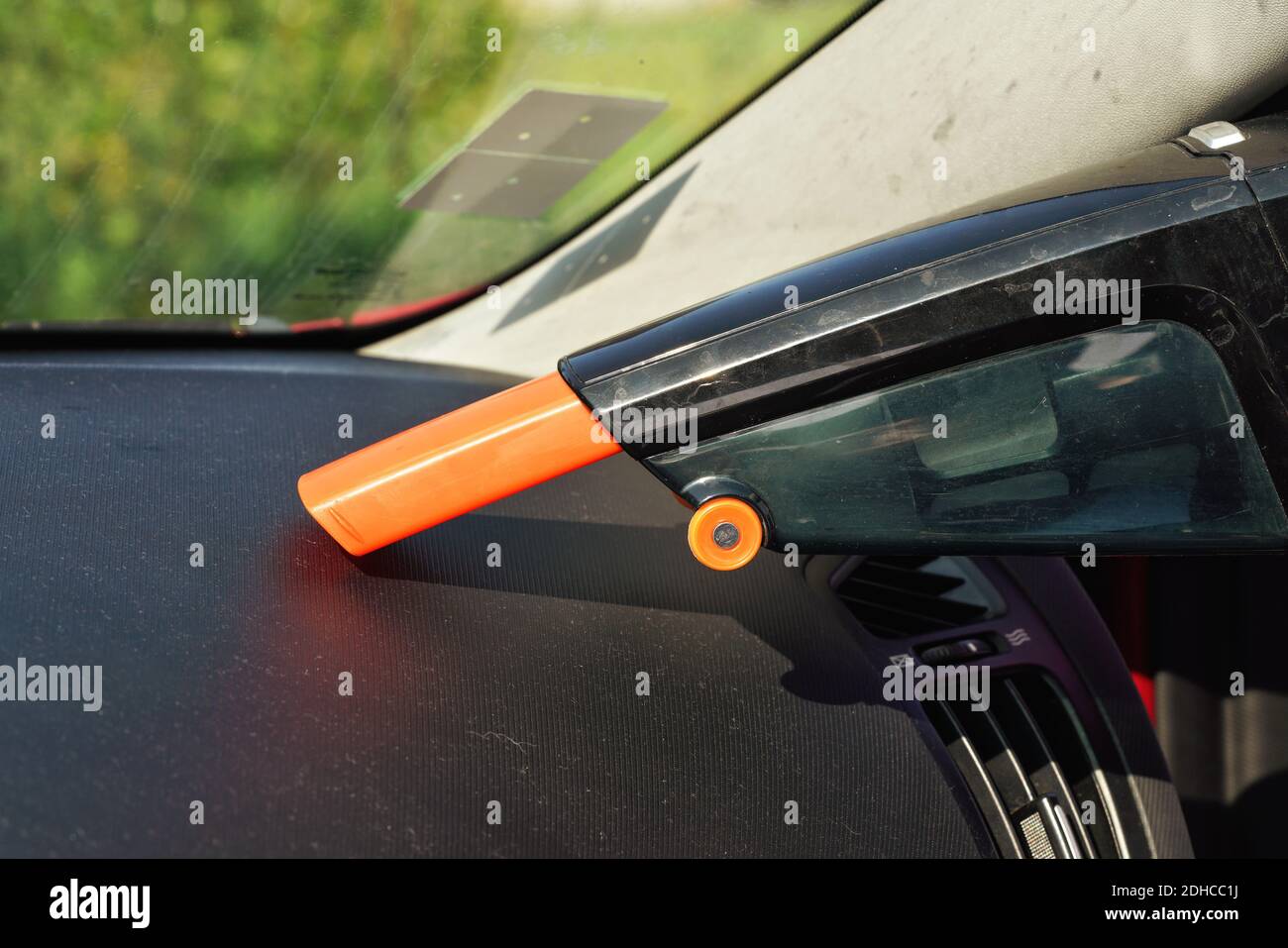 Car dashboard cleaned from dust with small orange portable vacuum cleaner Stock Photo