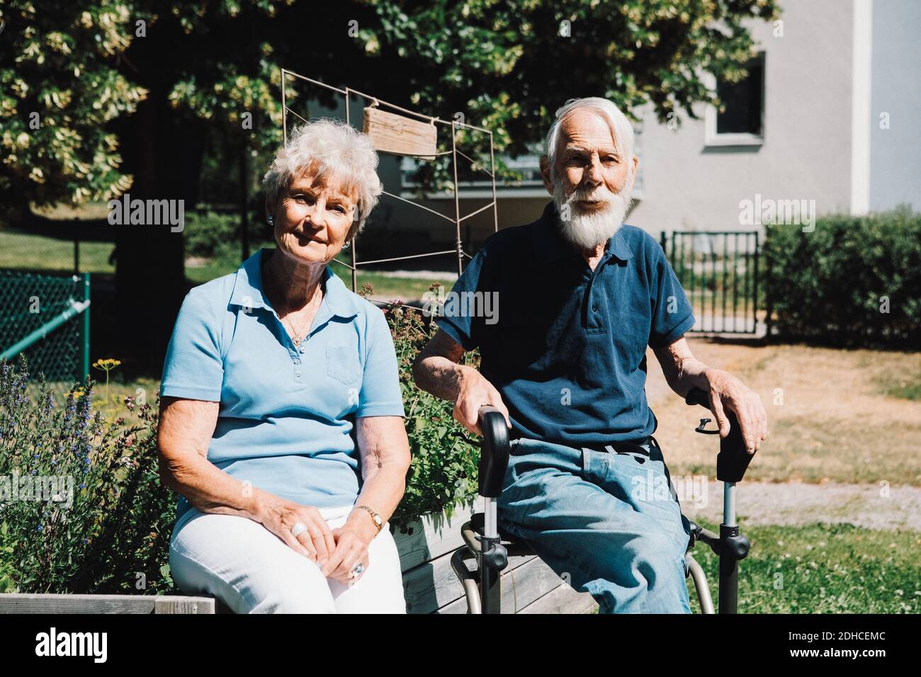 Portrait of smiling retired senior man and woman sitting at back yard Stock Photo