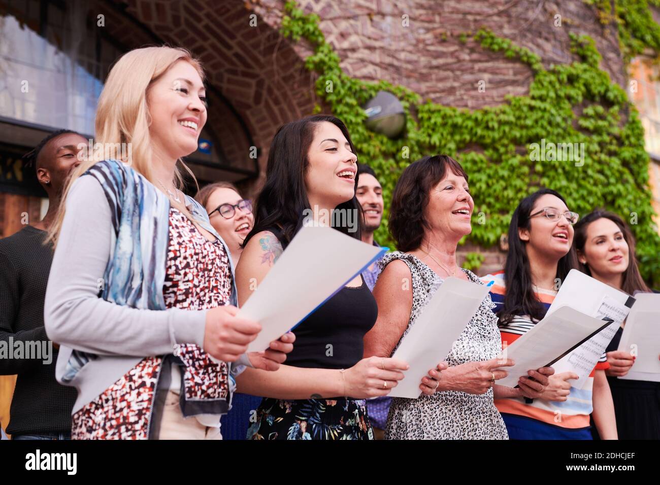 Multi-ethnic students singing in choir together outside language school Stock Photo
