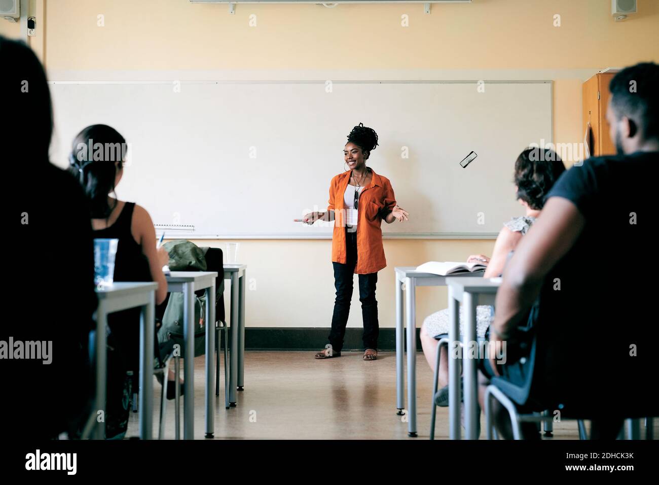 Teacher teaching language to students in classroom Stock Photo