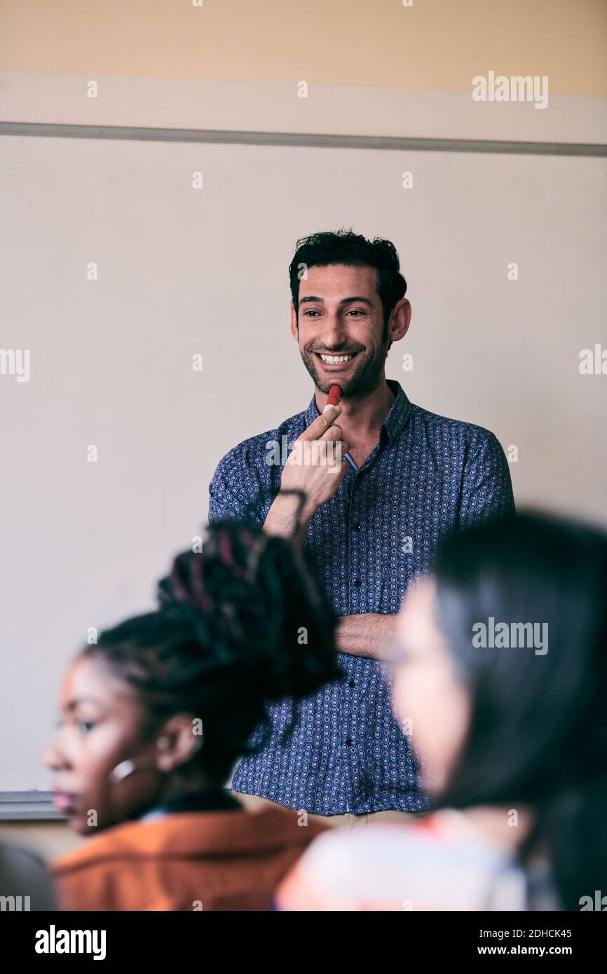 Young teacher smiling while looking at students in language class Stock Photo