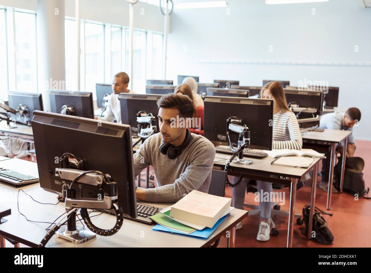 Male and female students using computers at library in university Stock Photo